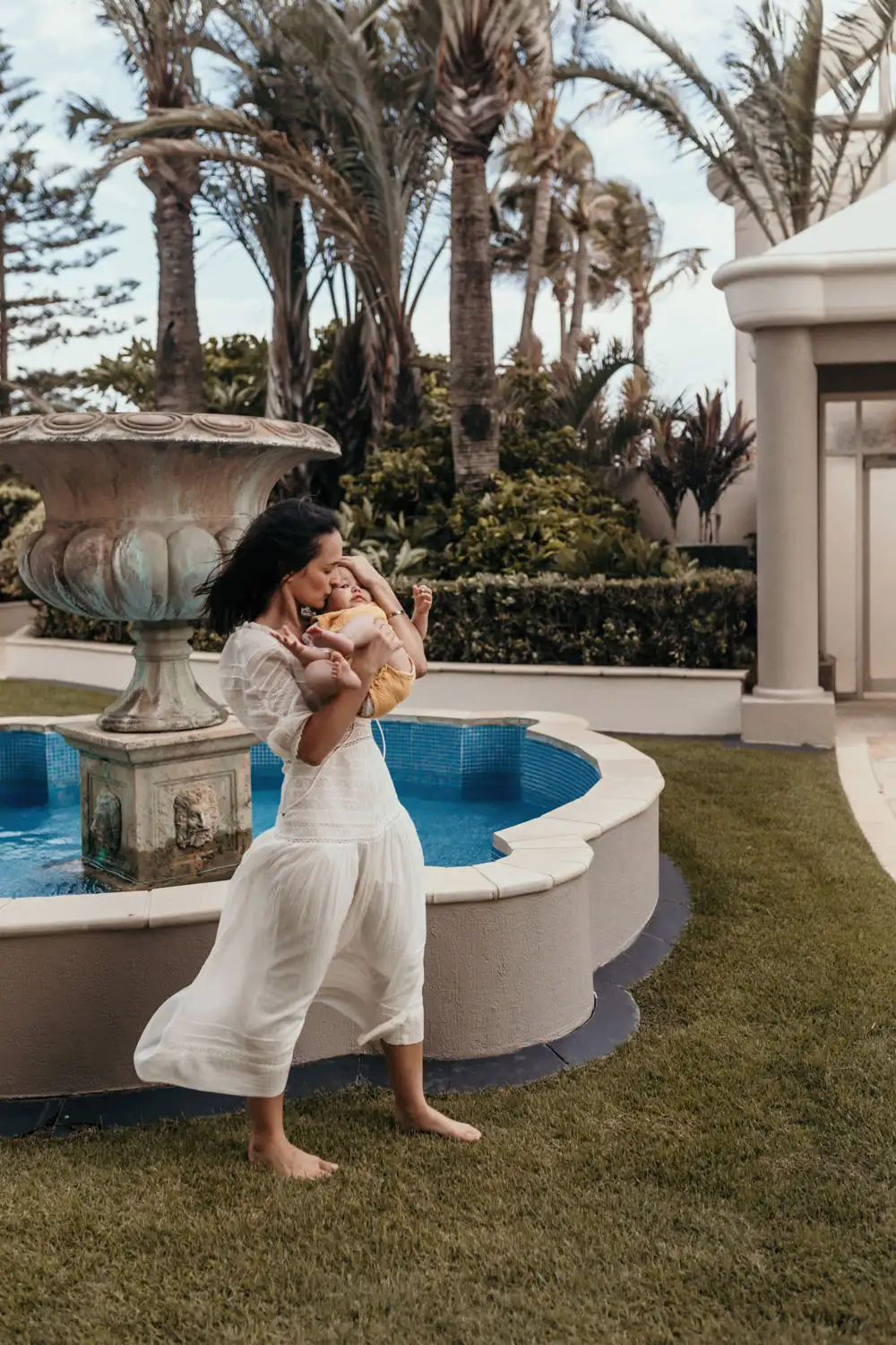 Mother holding baby as wind blows her dress