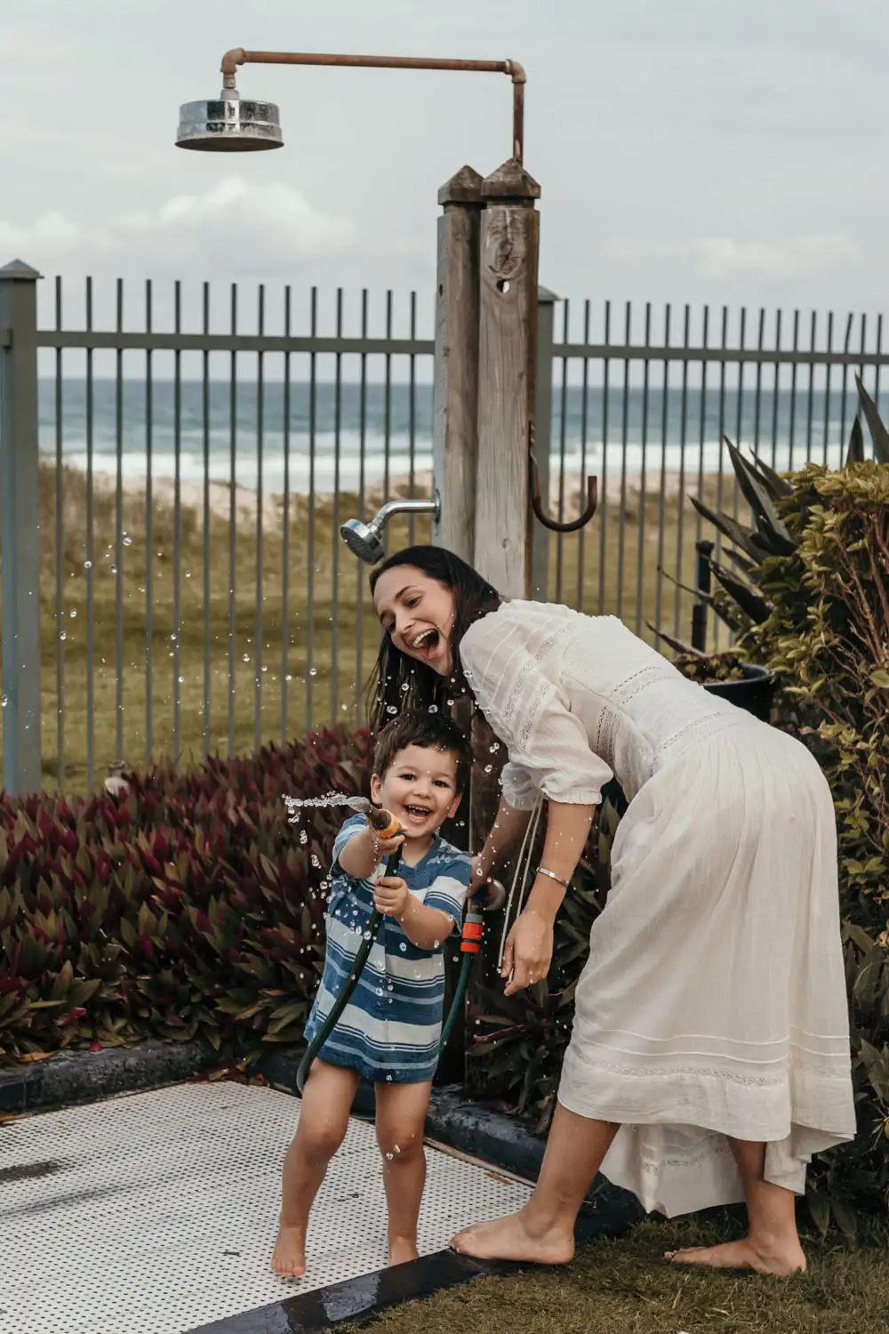 Mother and son playing with outdoor shower